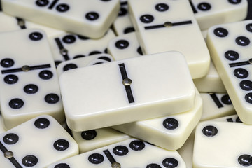 Dominoes is a family of board games , the game is played with dominoes tiles which are in this photo .