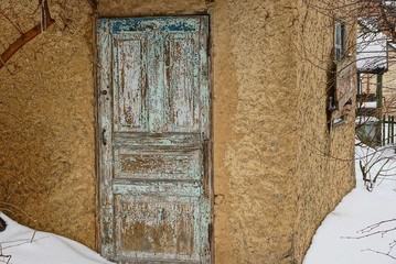 старые деревянные двери на стене сельского дома