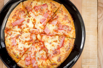 Pizza on wooden background top view.