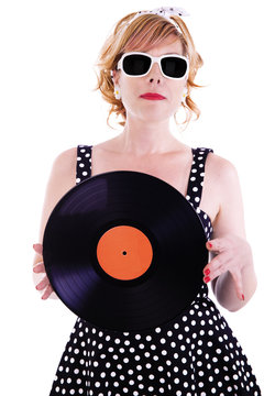 Attractive woman looks like a pinup, holding a vinyl record in her hands.