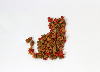 Heap of cat food set to cat shape sitting on the white floor. Cat food is food for consumption by cats. Cats have specific requirements for their dietary nutrients.