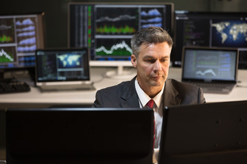 Stock Market Broker Looking At Multiple Computer Screen