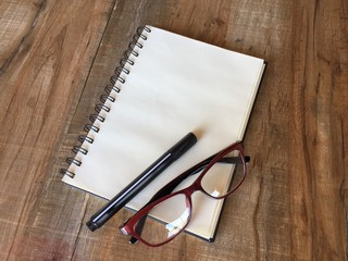 Notebook with pen and glasses 