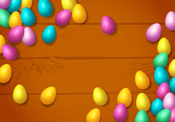 Easter frame with shiny colorful happy eggs spread over wooden background