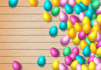 Easter frame with shiny colorful happy eggs spread over wooden background