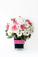 a modest bouquet of chamomiles and pink roses in a vase, a gift to a woman, spring and summer