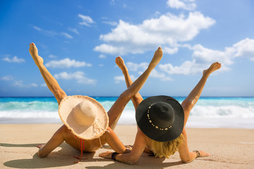 Two women with strasw hat suntanning in  Lefkas Greece