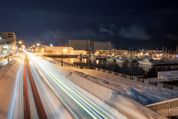 Long Exposure showing the movement of traffic light trails on the highway and beautiful twilight sky at otaru city ,Hokkaido,Japan.