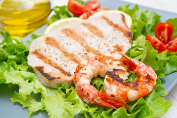 plate of grilled fish with salad and cherry tomatoes