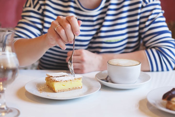 girl in striped clothes eating fork with dessert