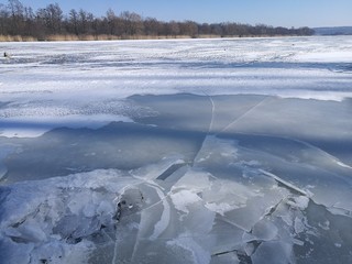 Kruchy, spękany lód na rzece.