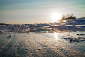 snowdrift on a frozen river during the sunset on a cold winter day