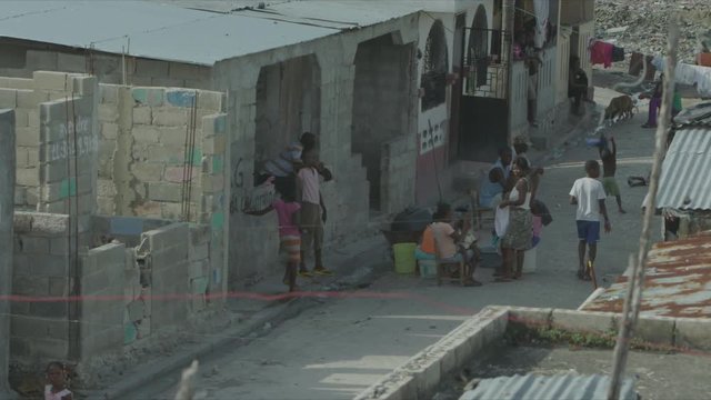 Kid Doing Hand Gesture to Camera, Street Life in Cité Soleil, Port-au-Prince