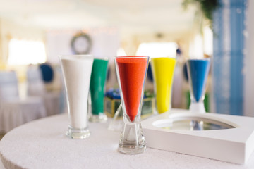 several glasses of sand for a sand ceremony