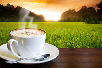 Cappuccino on the table with paddy rice field background 
