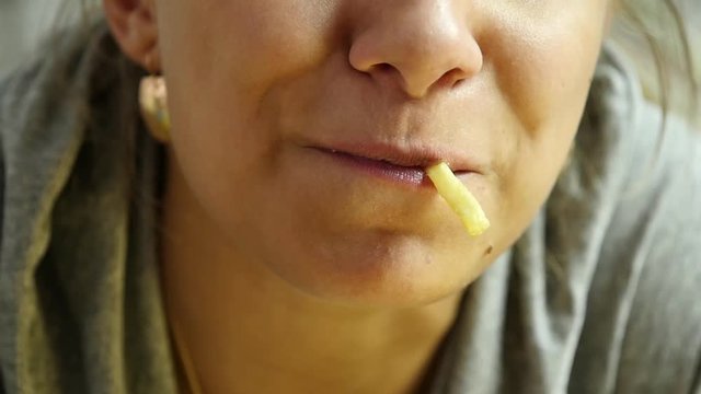 Woman eating junk food with great enjoyment. girl eats french fries. slow motion
