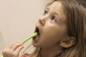 Cute little girl washing her teeth