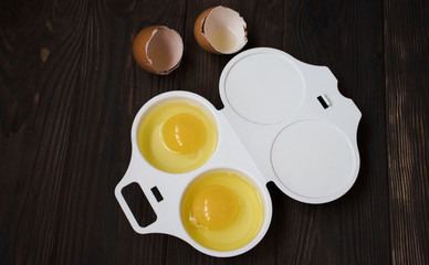 raw eggs in a container on wooden background. Top view.