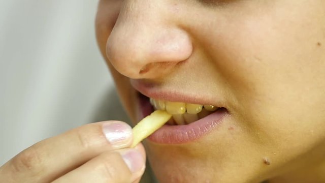 Woman eating junk food with great enjoyment. girl eats french fries. slow motion