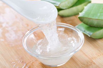Aloe vera gel in a spoon. Fresh aloe vera leaves and aloe vera juice