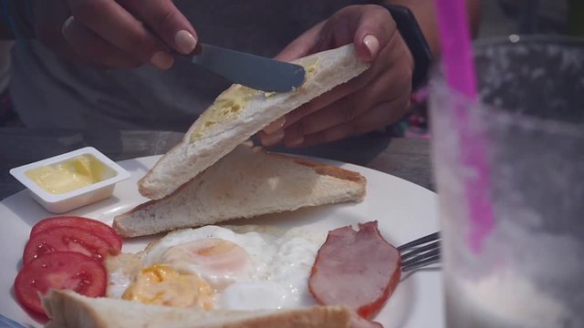 Eat eggs with bacon and a mummer, spread butter on toast.. Close up. HD, 1920x1080.