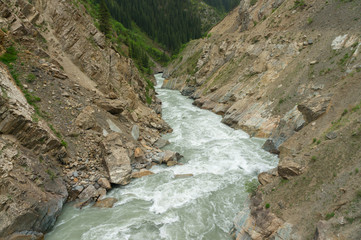 Fototapeta na wymiar Amazing mountain river sweeps along the gorge