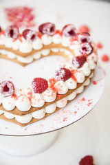Heart cake with whipped cream and raspberries