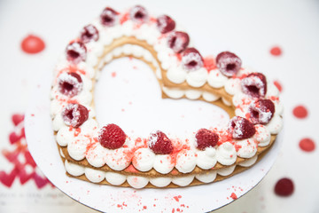Heart cake with whipped cream and raspberries
