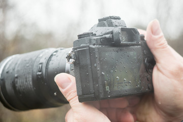 A photographer with a camera in the rain