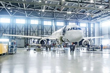 Photo sur Plexiglas Avion Avion de passagers sur l& 39 entretien de la réparation du moteur et du fuselage dans le hangar de l& 39 aéroport.