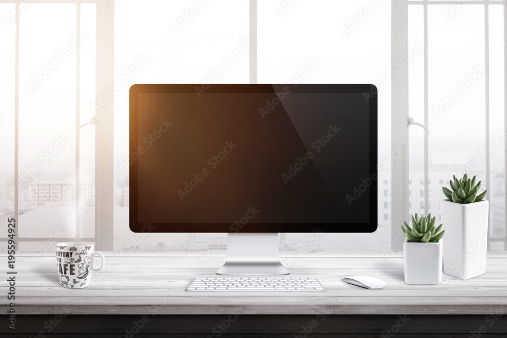 Poster Computer display with blank screen for mockup in office or work room. Window and sun light in background. Cup of coffee and two plants beside.