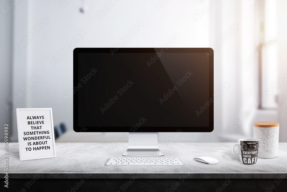 Poster modern computer display on office desk. picture frame, box and coffee mug beside.