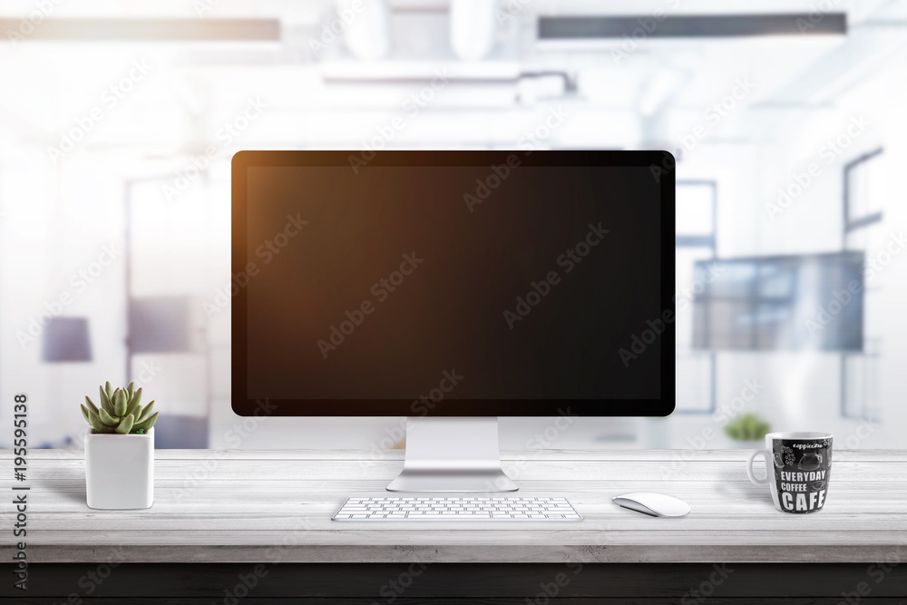 Poster empty computer display on office desk for mockup. plant and coffee mug beside.