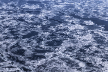 Blue sea surface with thin ice texture, background