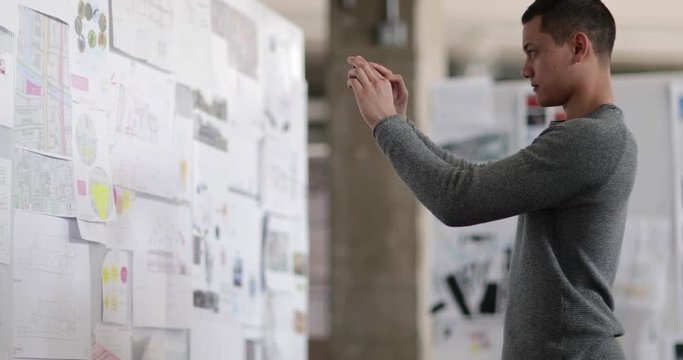 Designer taking photo of work with smartphone