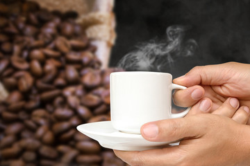 hand holding white coffee cup