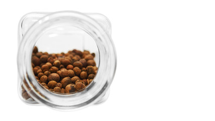 glass jar for spices with peas of pepper. Isolated on white background. copy space, template.