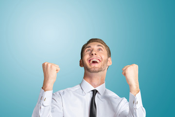 Successful business man celebrating with arms up