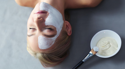 Face mask.Beautiful young girl at spa ,cosmetician woman applying facial mask