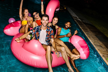 Friends hanging out at evening pool party