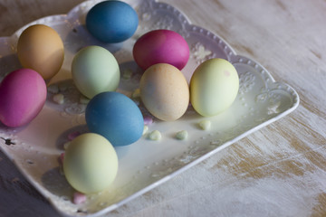 colorful  easter eggs on a plate and a dark wooden background