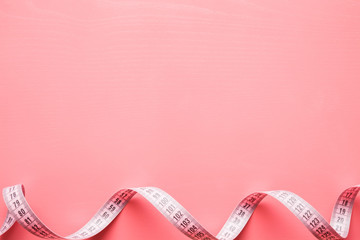 Measure tape on the pastel pink background. Mock up for body slimming, weight loss or dressmaker's...