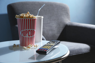 TV remote control and popcorn on table, closeup. Home cinema © Africa Studio