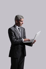 businessman standing with an open laptop