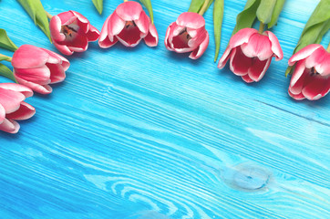 Tulip flowers on blue wooden table board background with copy space. Woman day concept. Mother day background. Saint Valentines day greeting card mock up. Top view.