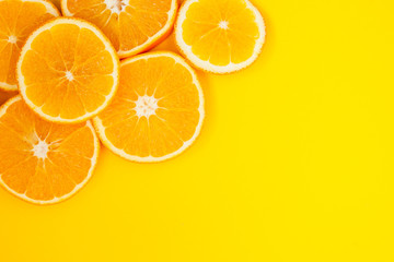 Round slices of orange lie on a yellow background, they have a lot of useful vitamins.