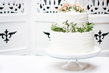 Wedding white cake decorated with wooden birds and eucalyptus on stand