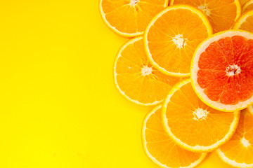 Pieces of yellow juicy orange and grifrut on a yellow background