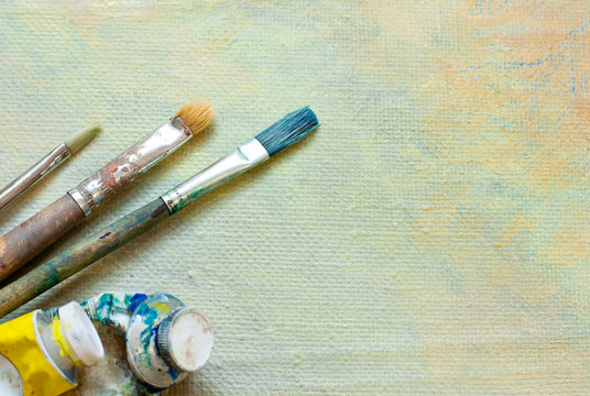 Paint brushes and oil tubes on oil canvas