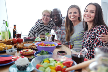 Top view of group of people having dinner together while sitting at wooden table. Food on the table. People eat fast food.